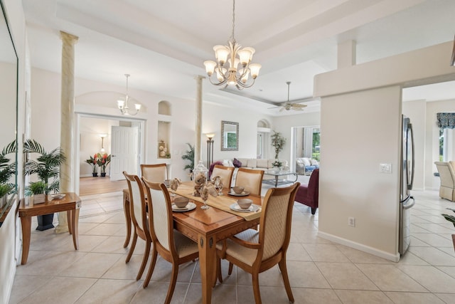 dining room with light tile patterned floors, a raised ceiling, and ceiling fan with notable chandelier