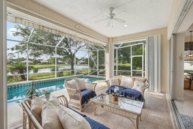 sunroom featuring ceiling fan, a water view, and an outdoor living space