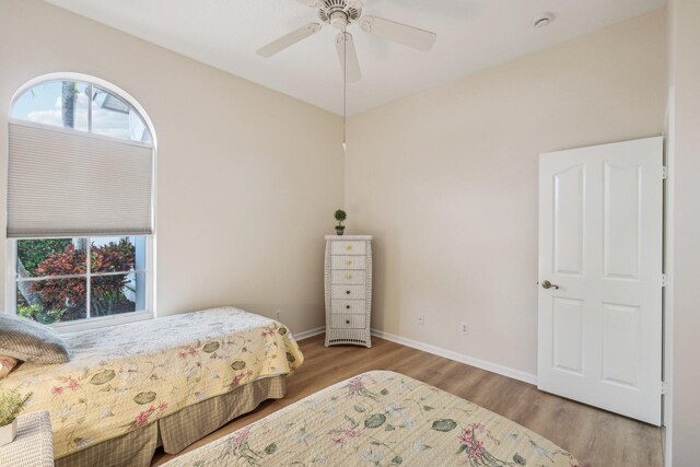 bedroom featuring ceiling fan, wood finished floors, and baseboards