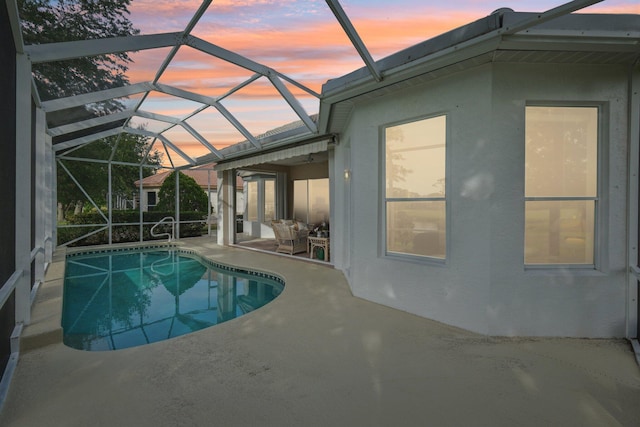 pool with a patio area and glass enclosure
