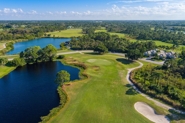 drone / aerial view with golf course view and a water view