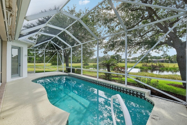 pool featuring glass enclosure, a water view, and a patio area