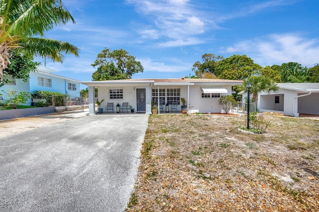 391 SW 2nd St, Boca Raton, FL 33432 - single story home with a tiled roof, stucco siding, driveway, and fence