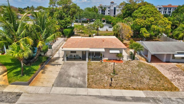 391 SW 2nd St, Boca Raton, FL 33432 - view of front of property with fence, a tile roof, concrete driveway, stucco siding, and an attached carport