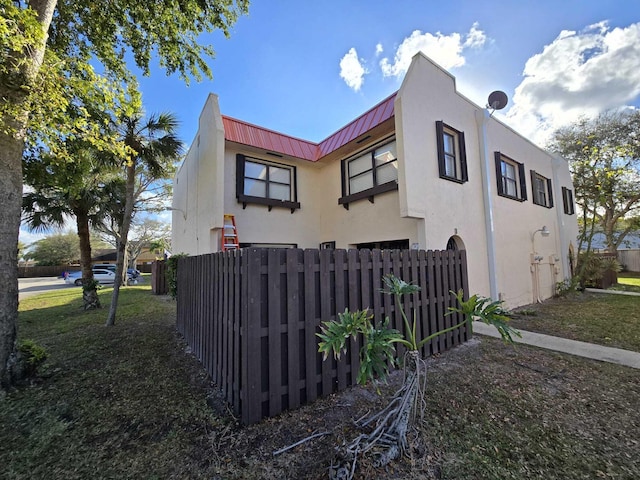 6363 Seven Springs Blvd Unit B, Greenacres, FL 33463 - view of home's exterior with stucco siding, a standing seam roof, metal roof, and fence