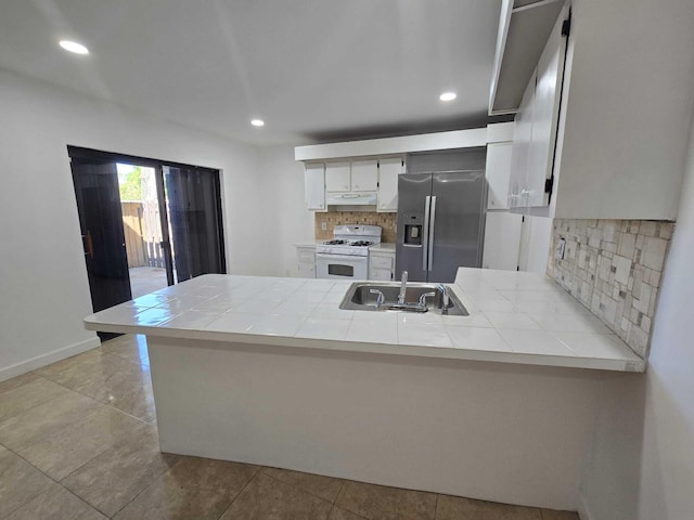 6363 Seven Springs Blvd Unit B, Greenacres, FL 33463 - kitchen featuring tile countertops, a sink, gas range gas stove, a peninsula, and stainless steel fridge