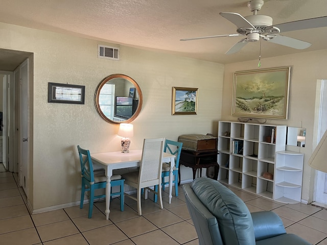 180 NE Lobster Rd, Port Saint Lucie, FL 34986 - dining room featuring visible vents, a textured wall, a textured ceiling, a ceiling fan, and light tile patterned floors