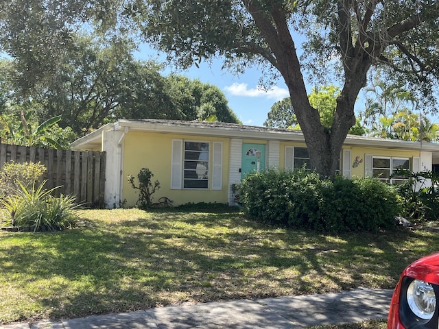 180 NE Lobster Rd, Port Saint Lucie, FL 34986 - ranch-style home featuring fence, stucco siding, and a front lawn