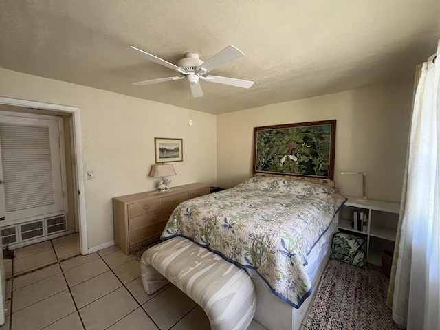 180 NE Lobster Rd, Port Saint Lucie, FL 34986 - bedroom featuring light tile patterned flooring, a ceiling fan, baseboards, and a textured ceiling
