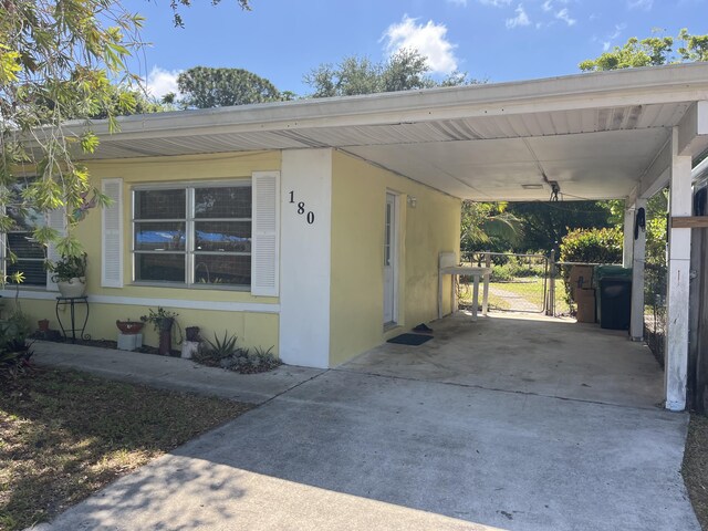 180 NE Lobster Rd, Port Saint Lucie, FL 34986 - exterior space with a gate, stucco siding, an attached carport, and driveway