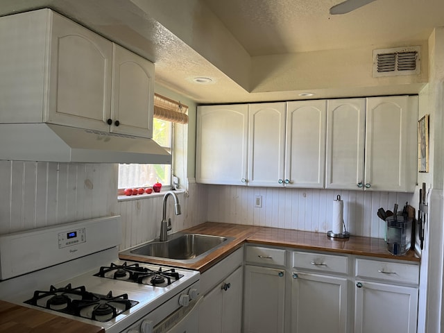 180 NE Lobster Rd, Port Saint Lucie, FL 34986 - kitchen with a sink, under cabinet range hood, white range with gas cooktop, and white cabinetry