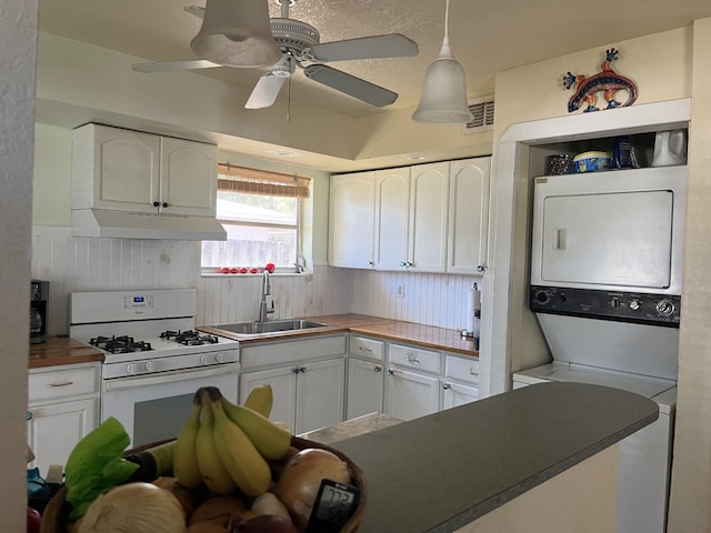 180 NE Lobster Rd, Port Saint Lucie, FL 34986 - kitchen with white cabinets, white range with gas cooktop, a sink, and stacked washer and clothes dryer