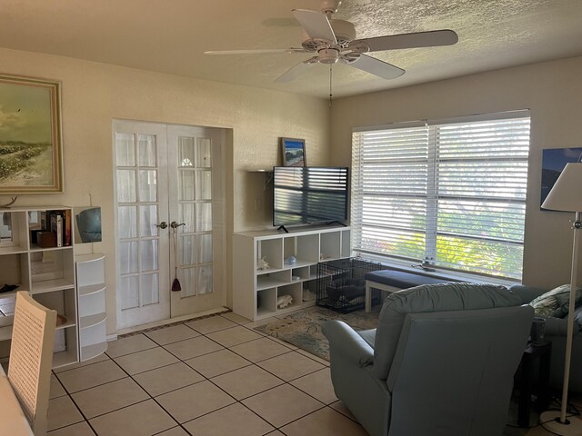 180 NE Lobster Rd, Port Saint Lucie, FL 34986 - tiled living room with french doors and ceiling fan