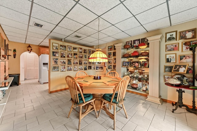 5725 Basil Dr, West Palm Beach, FL 33415 - dining room featuring a paneled ceiling, ornate columns, light tile patterned flooring, and baseboards
