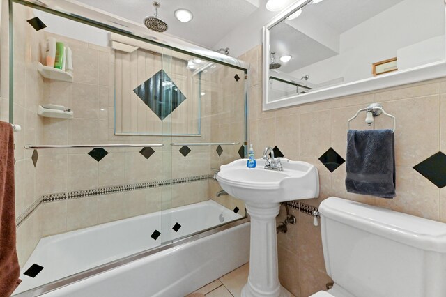 5725 Basil Dr, West Palm Beach, FL 33415 - full bathroom with tile walls, toilet, a combined bath / shower with rainfall shower, and tile patterned flooring