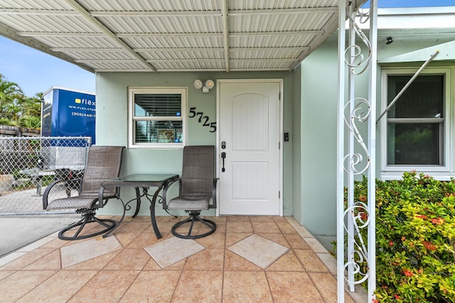 5725 Basil Dr, West Palm Beach, FL 33415 - view of exterior entry featuring fence, stucco siding, and a patio
