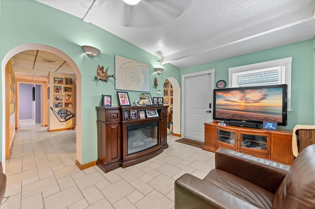 5725 Basil Dr, West Palm Beach, FL 33415 - living room featuring arched walkways, a textured ceiling, ceiling fan, and baseboards