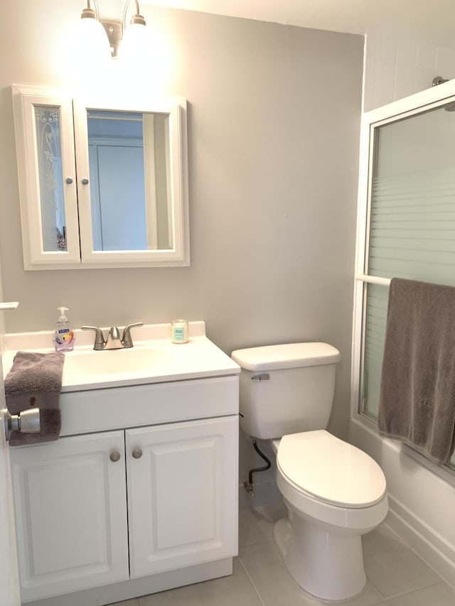 full bathroom with tile patterned flooring, shower / bath combination with glass door, toilet, and vanity