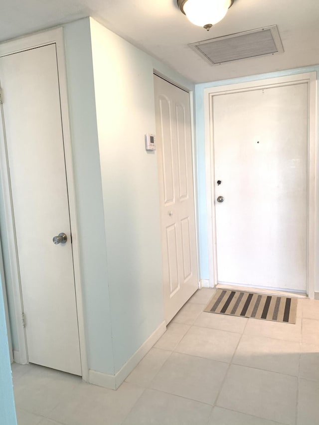 hallway with baseboards and light tile patterned floors