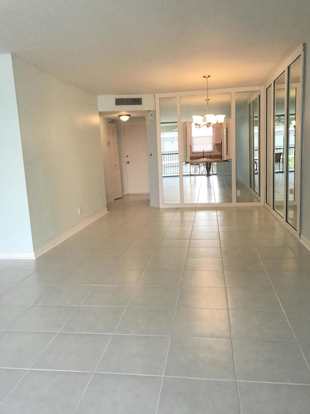 unfurnished room featuring light tile patterned floors, baseboards, an inviting chandelier, and visible vents