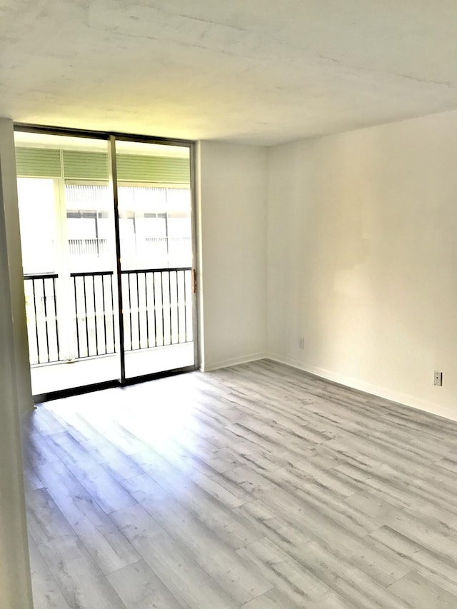 empty room with baseboards and wood finished floors