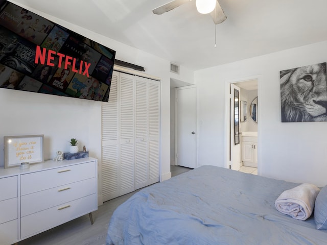 bedroom with ensuite bath, a ceiling fan, visible vents, and a closet