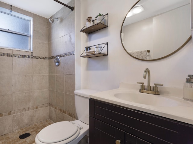 full bath featuring vanity, toilet, and tiled shower