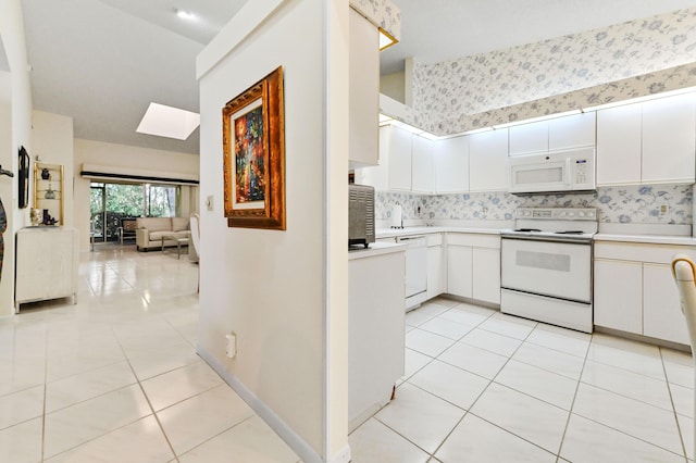 6040 Waldwick Cir, Delray Beach, FL 33484 - kitchen featuring white appliances, light countertops, light tile patterned floors, and a skylight