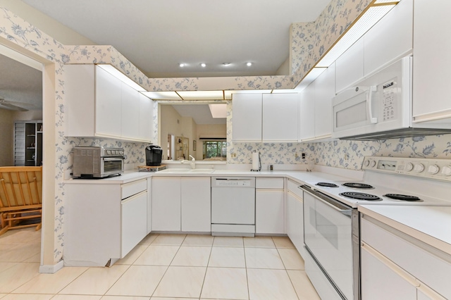 6040 Waldwick Cir, Delray Beach, FL 33484 - kitchen featuring white appliances, white cabinets, light tile patterned flooring, light countertops, and a sink