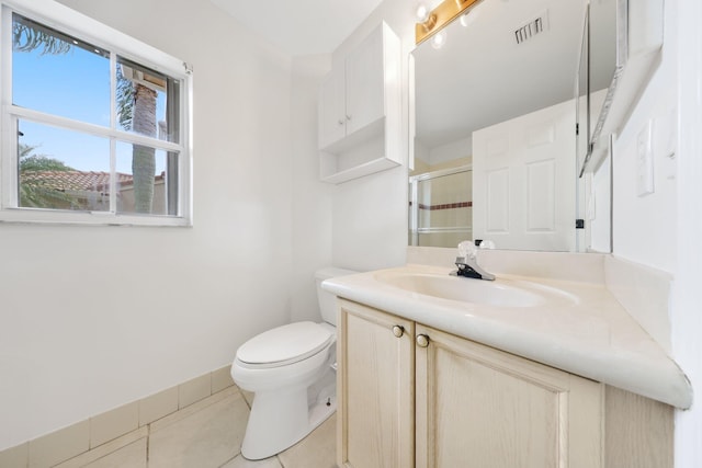 bathroom with visible vents, toilet, vanity, tile patterned floors, and a stall shower