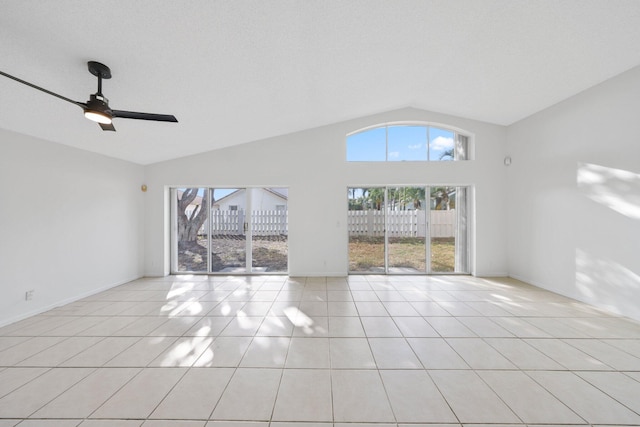 unfurnished living room with light tile patterned floors, baseboards, a ceiling fan, and lofted ceiling