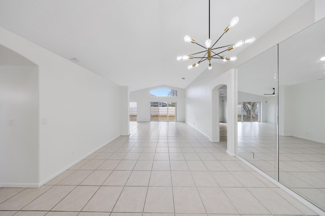 unfurnished room with baseboards, arched walkways, a notable chandelier, light tile patterned flooring, and lofted ceiling