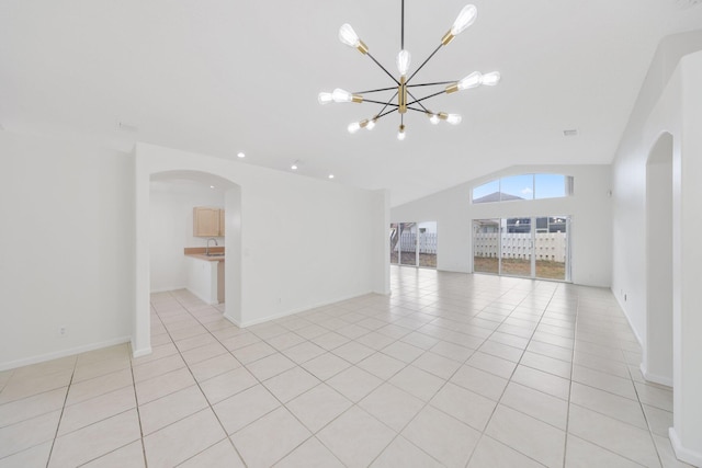 unfurnished living room with arched walkways, an inviting chandelier, light tile patterned flooring, and lofted ceiling