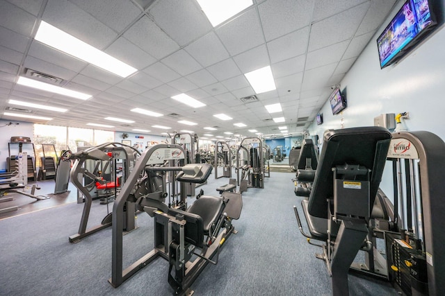 exercise room with a paneled ceiling and visible vents
