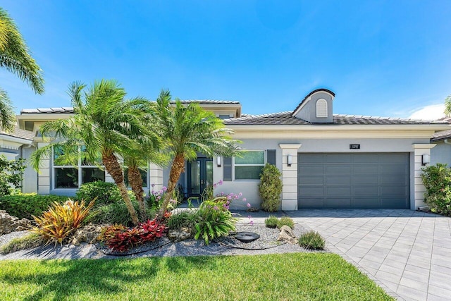 12797 Cariboo Ridge Rd, Boynton Beach, FL 33473 - view of front of house featuring an attached garage, decorative driveway, stucco siding, and a tile roof