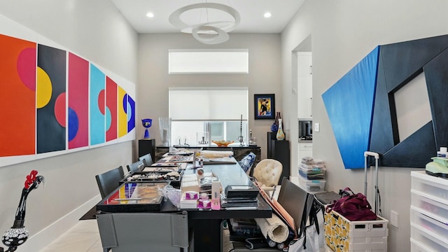dining area with baseboards, a towering ceiling, and recessed lighting
