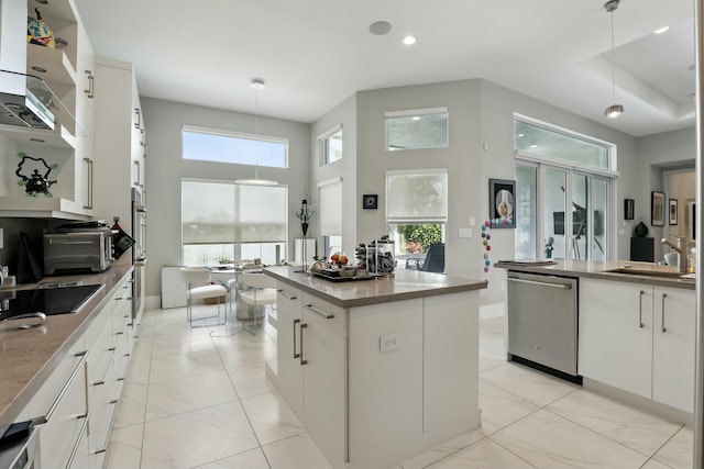 kitchen featuring decorative light fixtures, a sink, appliances with stainless steel finishes, and a healthy amount of sunlight