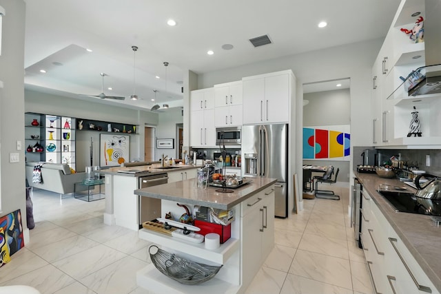 kitchen with recessed lighting, open shelves, visible vents, a kitchen island, and appliances with stainless steel finishes