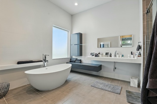 full bathroom with a freestanding tub, tile patterned floors, a shower, and a towering ceiling