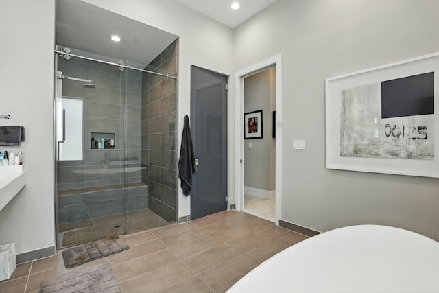 full bath with a freestanding bath, a shower stall, baseboards, and recessed lighting