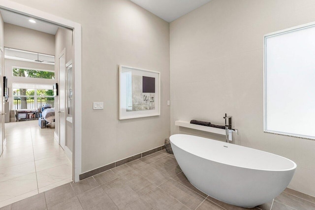 12797 Cariboo Ridge Rd, Boynton Beach, FL 33473 - bathroom featuring a freestanding tub, a towering ceiling, and tile patterned floors
