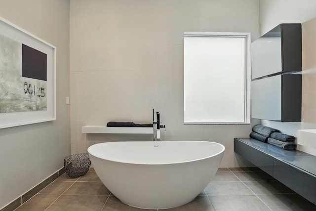 full bath featuring a freestanding bath and tile patterned flooring