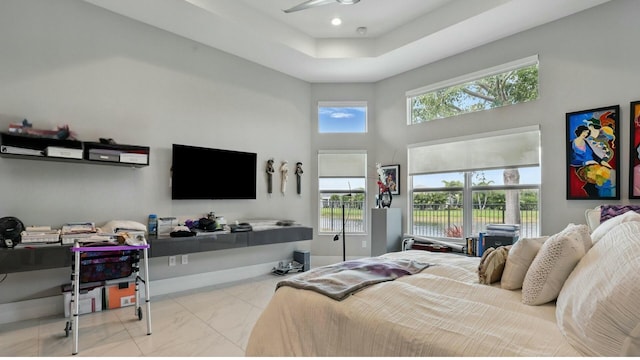 bedroom with a high ceiling, marble finish floor, and baseboards