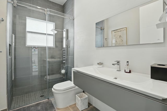 full bath with tile patterned floors, toilet, a stall shower, decorative backsplash, and vanity