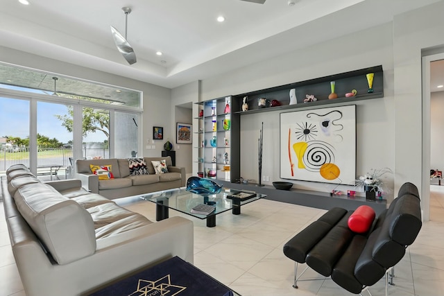 living room featuring a raised ceiling and recessed lighting