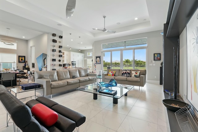 living room with a raised ceiling, a towering ceiling, recessed lighting, a ceiling fan, and light tile patterned floors