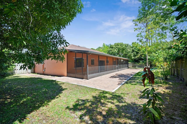 116 Churchill Dr, Royal Palm Beach, FL 33411 - back of property featuring a fenced backyard, a sunroom, a lawn, and stucco siding