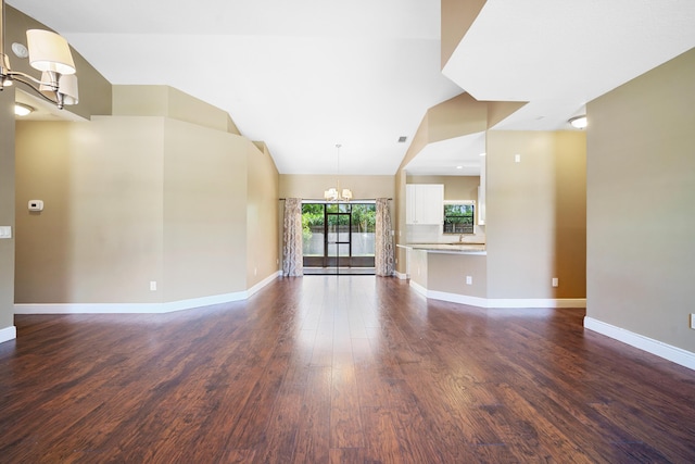 116 Churchill Dr, Royal Palm Beach, FL 33411 - unfurnished living room with dark wood finished floors, baseboards, a notable chandelier, and vaulted ceiling