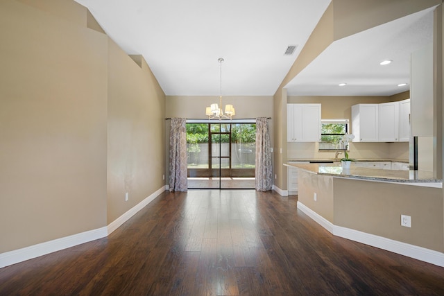 116 Churchill Dr, Royal Palm Beach, FL 33411 - kitchen featuring light stone countertops, visible vents, baseboards, and a notable chandelier