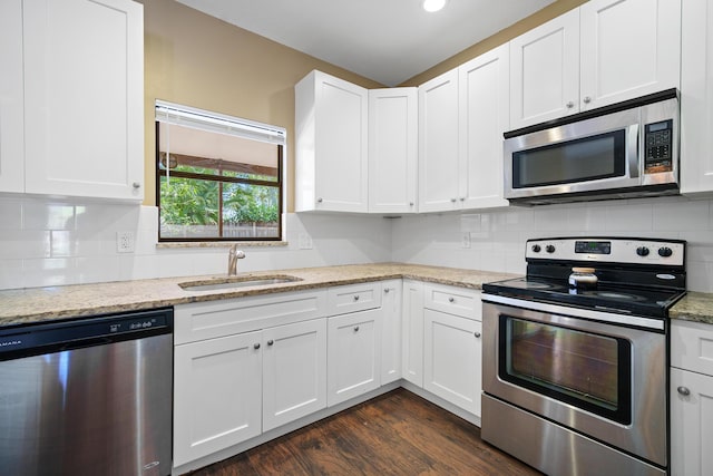 116 Churchill Dr, Royal Palm Beach, FL 33411 - kitchen featuring stainless steel appliances, white cabinetry, a sink, light stone countertops, and dark wood-style flooring